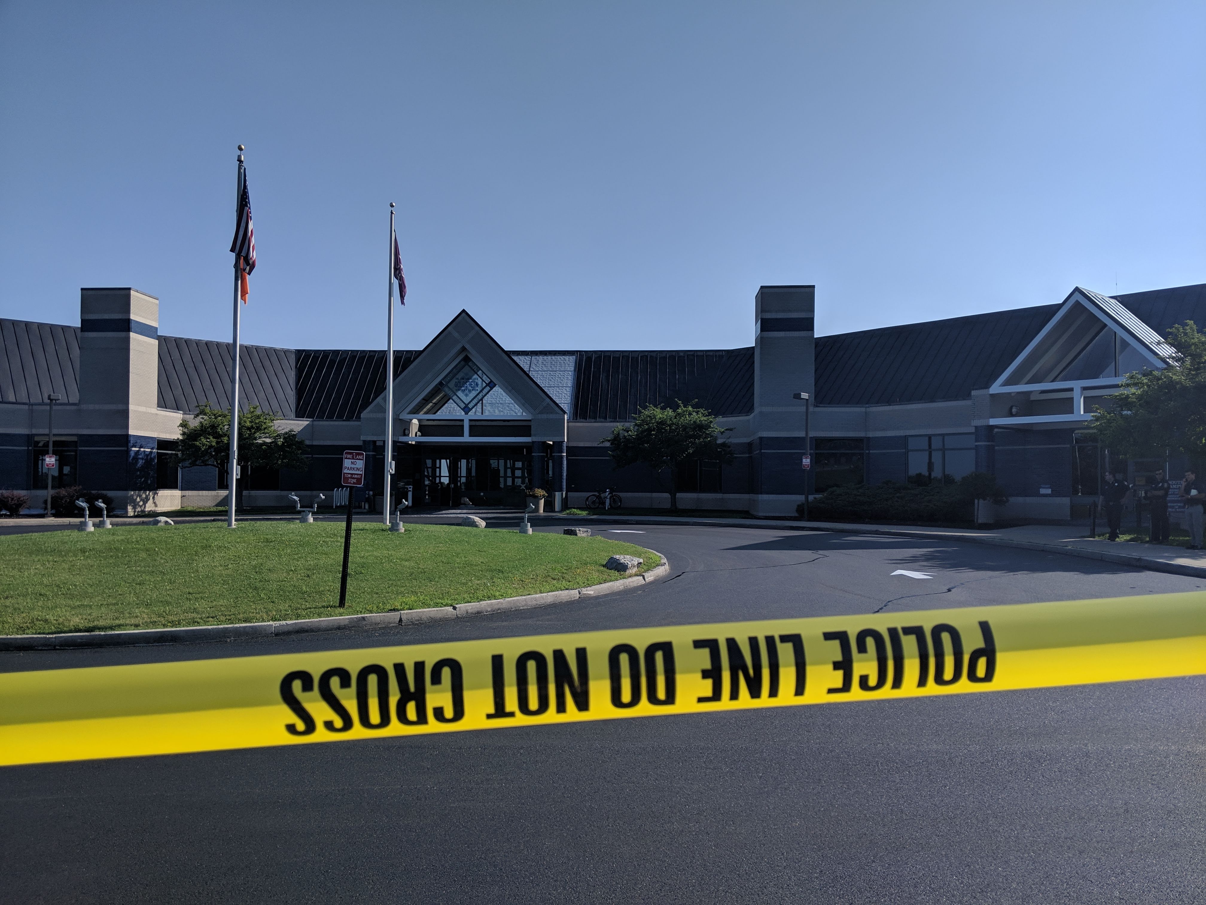 A building with yellow crime scene tape in front of it.